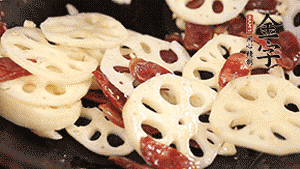 依次下香腸片、藕片翻炒均勻，加適量清水燜熟。