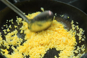 大火加熱炒鍋，再入油，燒到四至五成熱時倒入雞蛋液，在未凝結(jié)之前，加米飯煸炒，不停翻炒并用鍋鏟將成塊的米飯碾開、撥散。