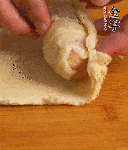 吐司卷起香腸，吐司尾端涂抹少許全蛋液，卷好的吐司表面蘸上蛋液，在裹上一層面包糠，送入預(yù)熱好的烤箱中。