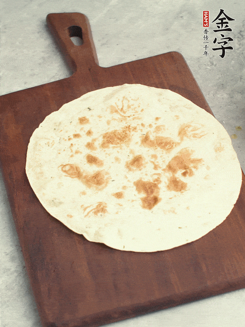 食材依次鋪在卷餅皮上，卷起來。