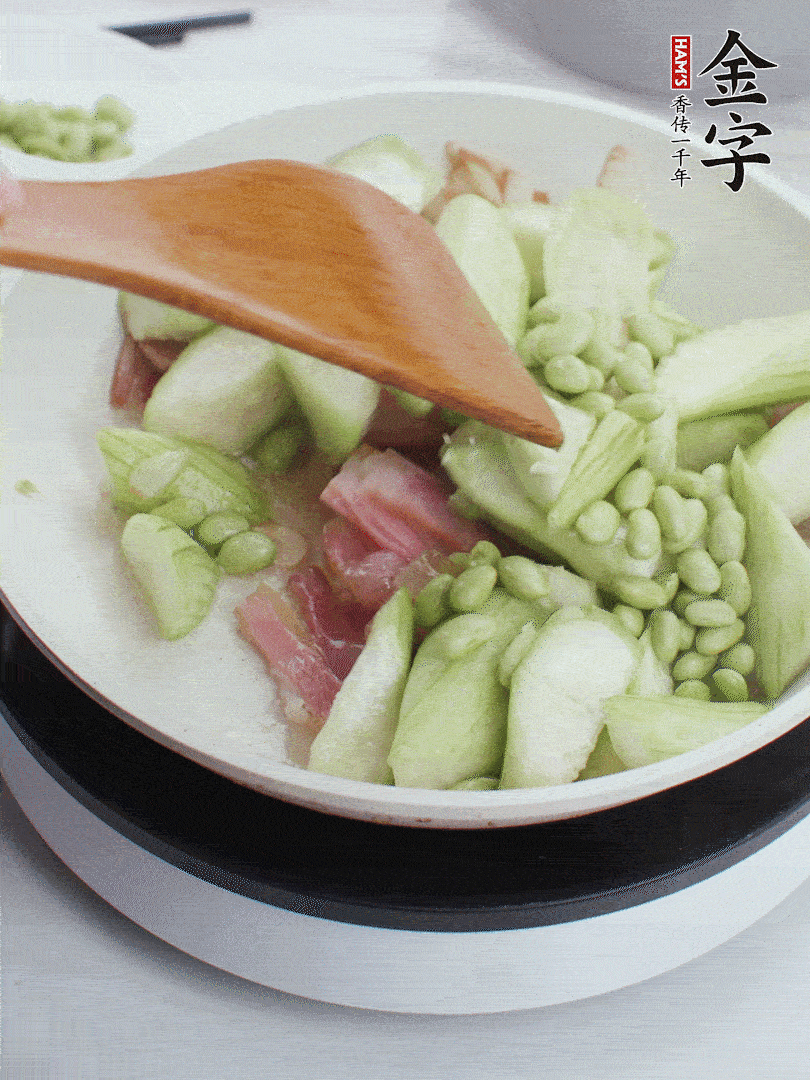 依次下絲瓜、青豆翻炒，炒至絲瓜打蔫縮小。
