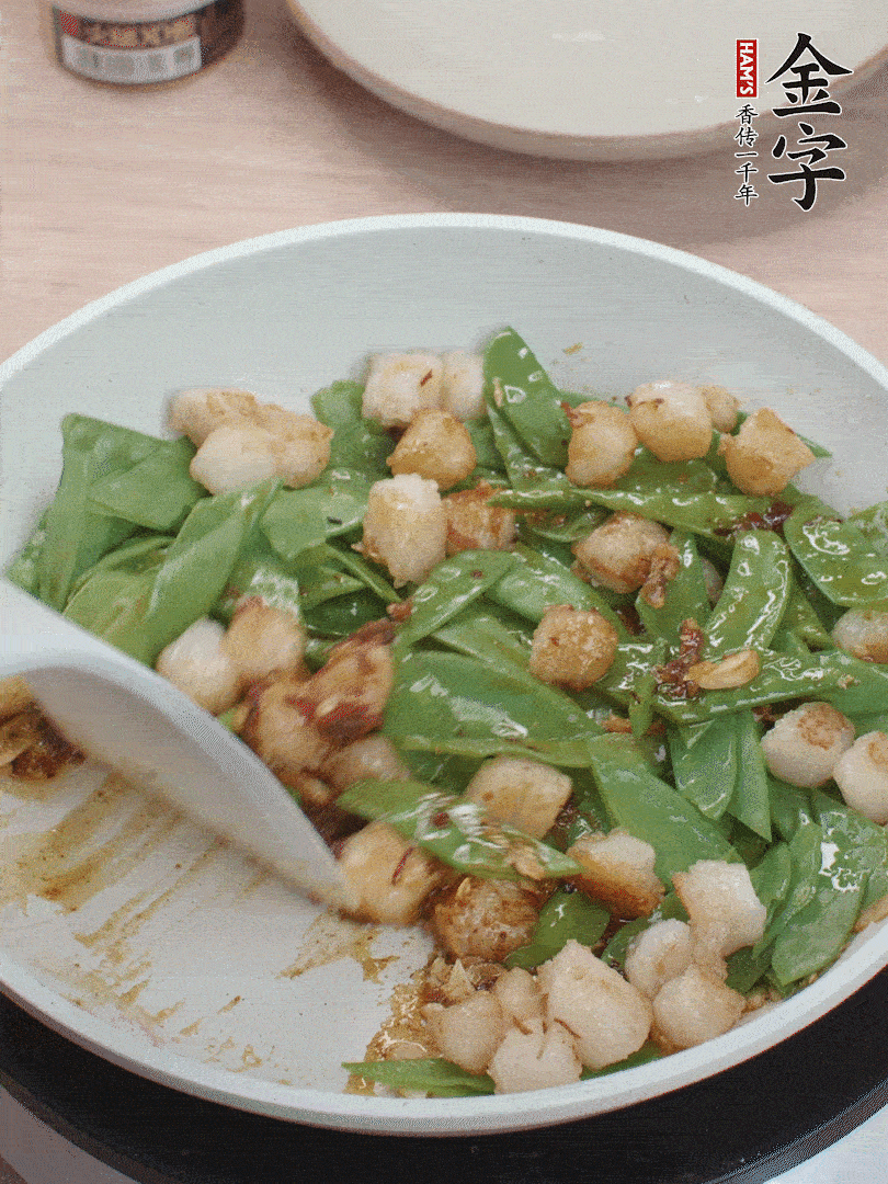 下甜豆莢、鮮貝輕輕翻炒均勻。