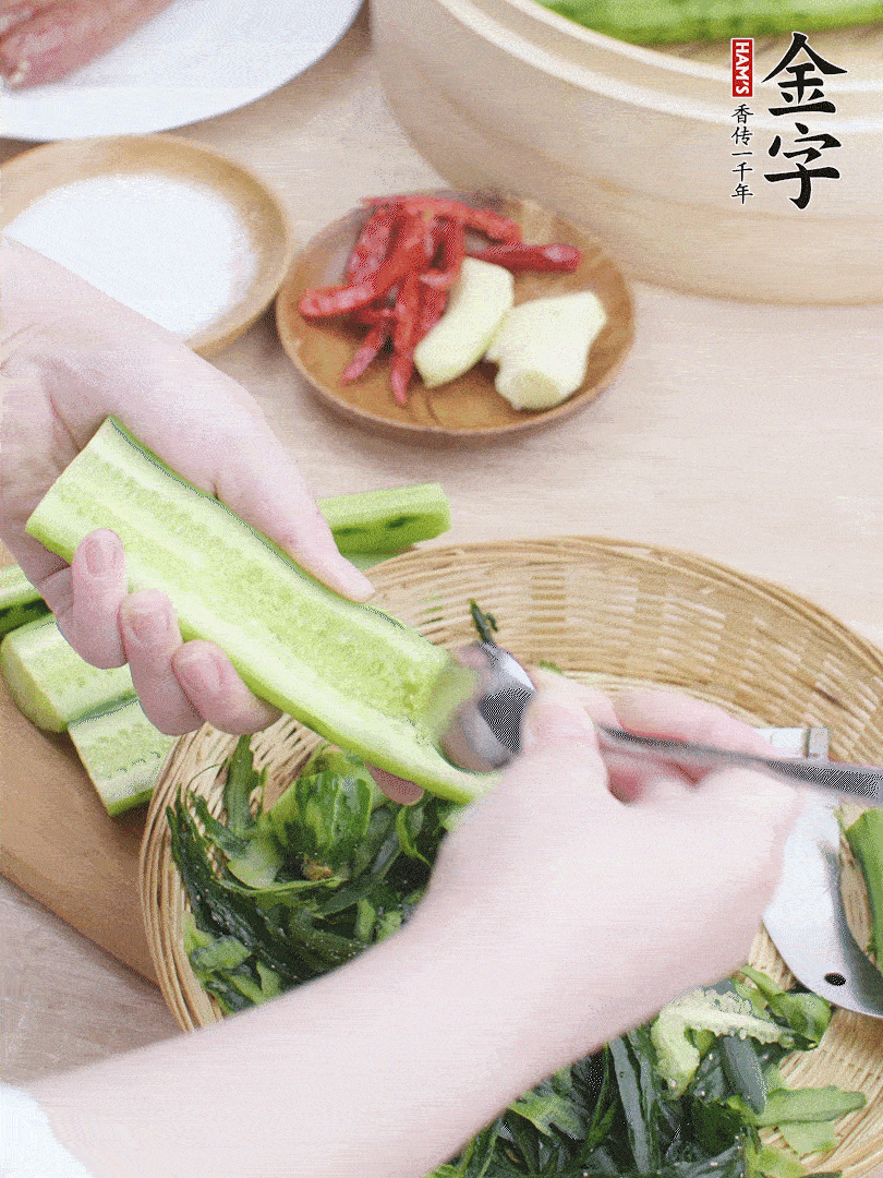 黃瓜削皮，對半切開，勺子挖去內(nèi)瓤，斜刀切片。青蒜斜刀切段。