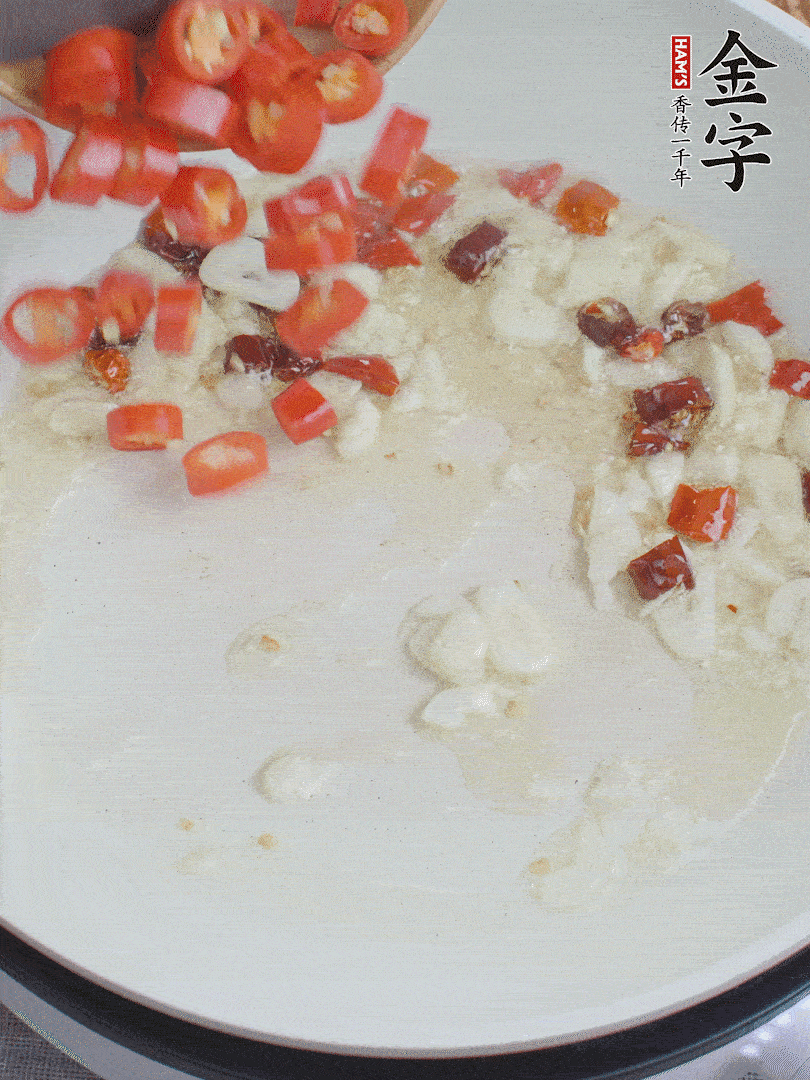 油6成熱，下蒜末、干紅辣椒煸炒，出香味后再放美人椒、香腸。