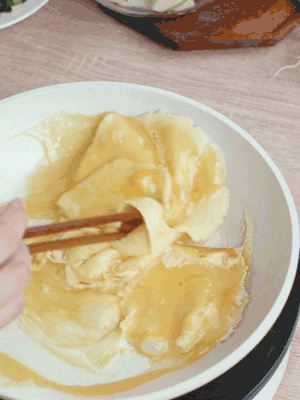 油6成熱時(shí)，下雞蛋液，邊緣凝固時(shí)翻拌成塊狀。