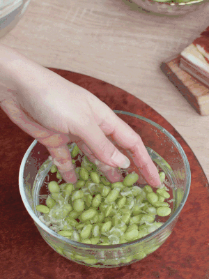 青豆剝殼，搓去外衣。