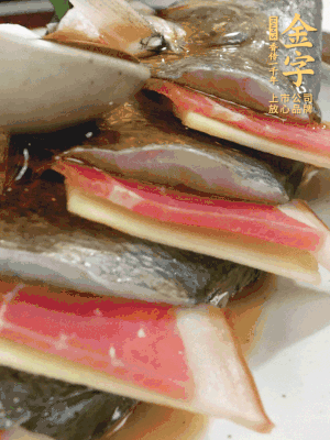 魚肚中塞蔥結(jié)、火腿片，魚身上碼放姜片、火腿片，倒入混合的料汁。
